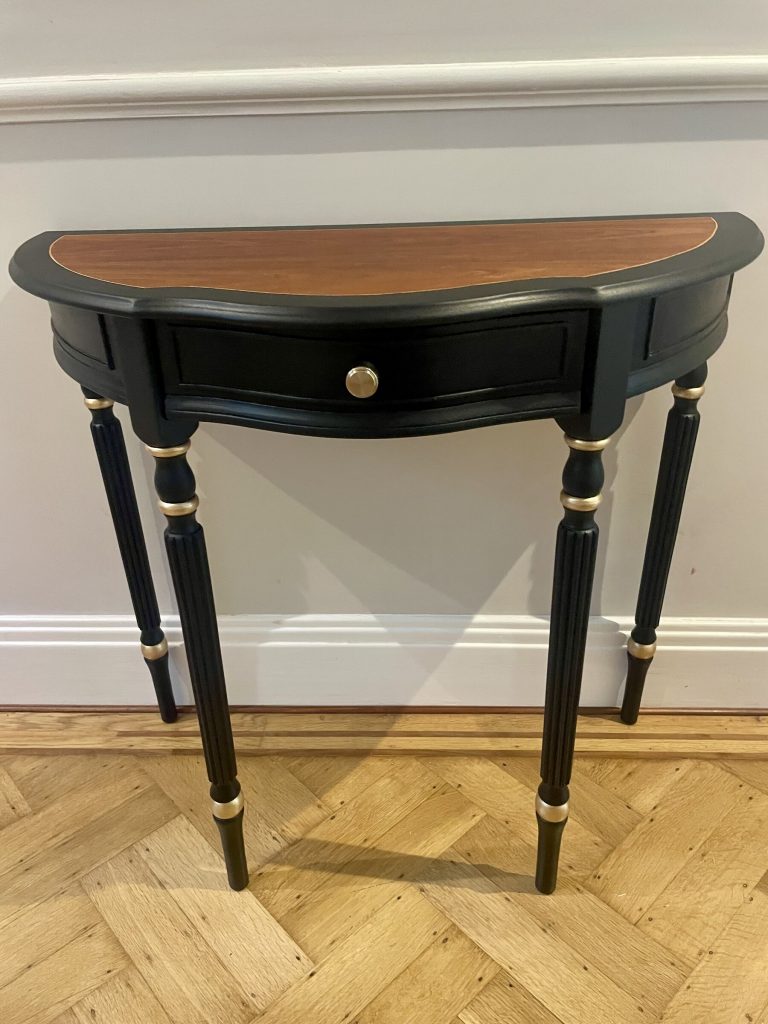 Front view of the Demi-Lune Console showing the black frame and wood top