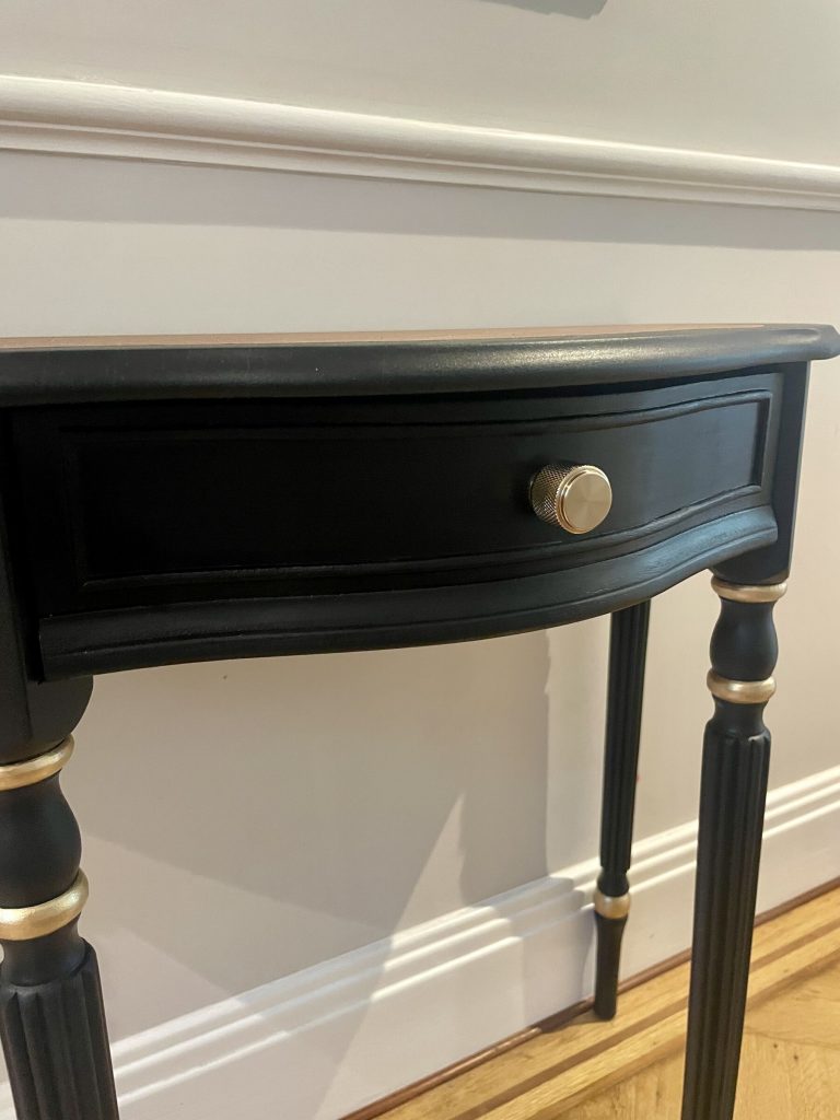 The shaped drawer front with its ribbed brass knob